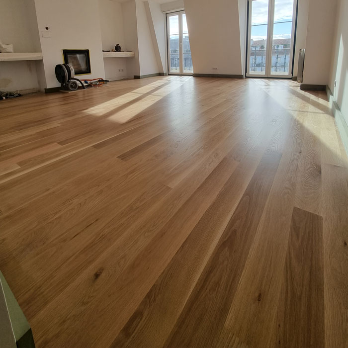 Sala ampla com soalho de madeira envernizado