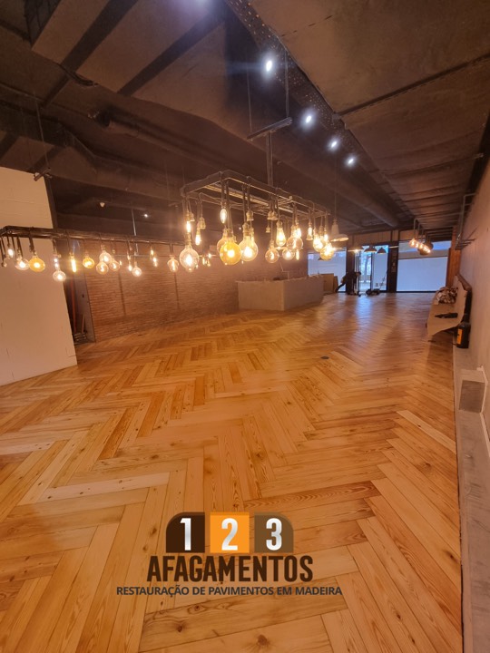 Pavimento em espinha concluído, sob a iluminação do restaurante