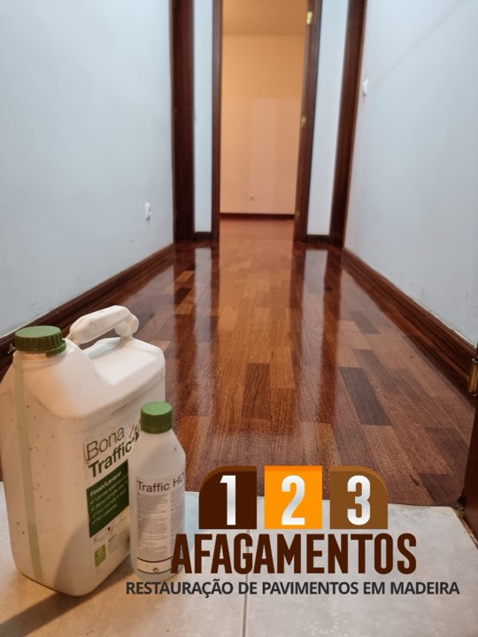 Corredor com o lamparquet envernizado e uma embalagem de verniz em primeiro plano
